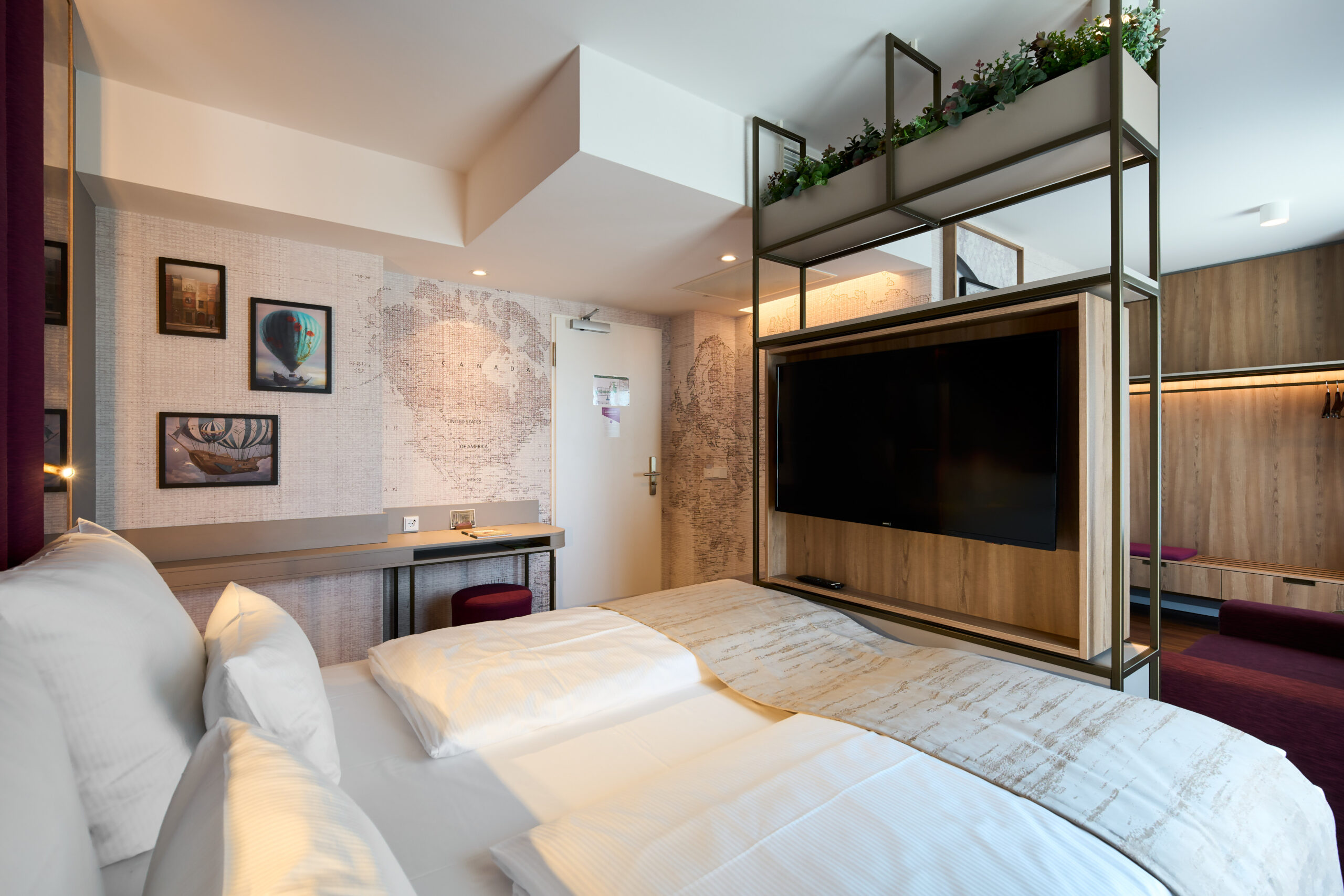 Schlafzimmer mit Doppelbett, Fernseher und moderner Einrichtung in einem Hotel.